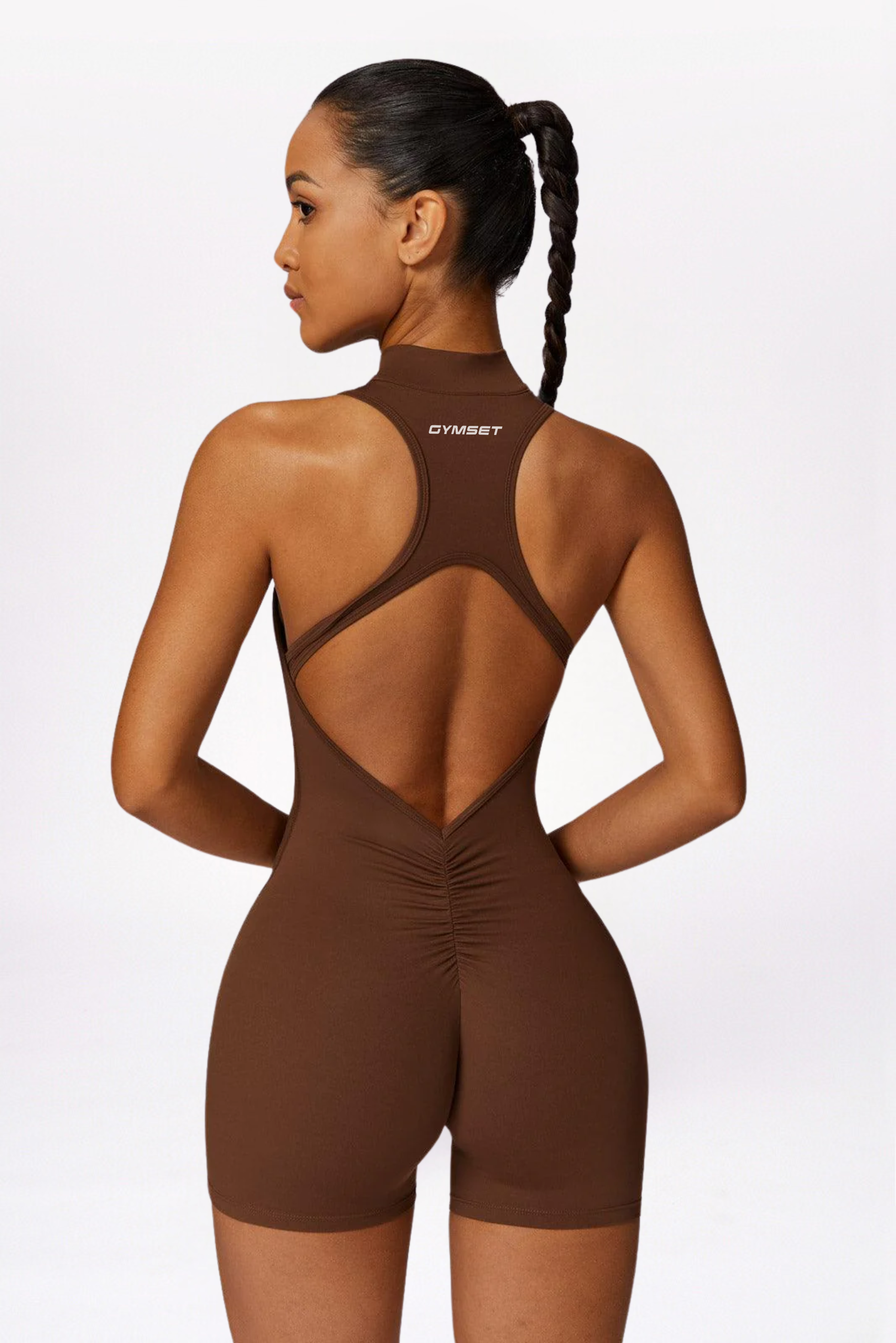 Woman wearing a brown bodysuit with 'gymelle' branding on a white background