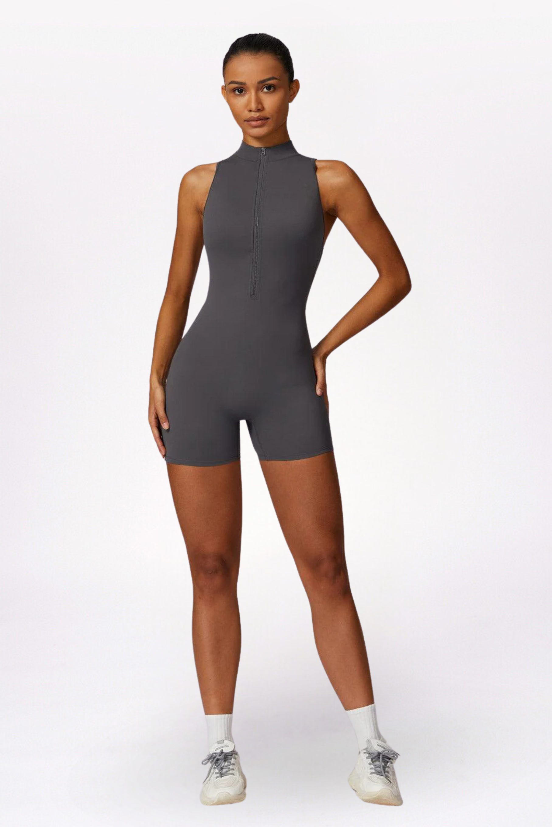 Woman wearing a gray sleeveless jumpsuit on a white background