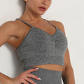 Woman wearing a gray sports bra and leggings against a white background
